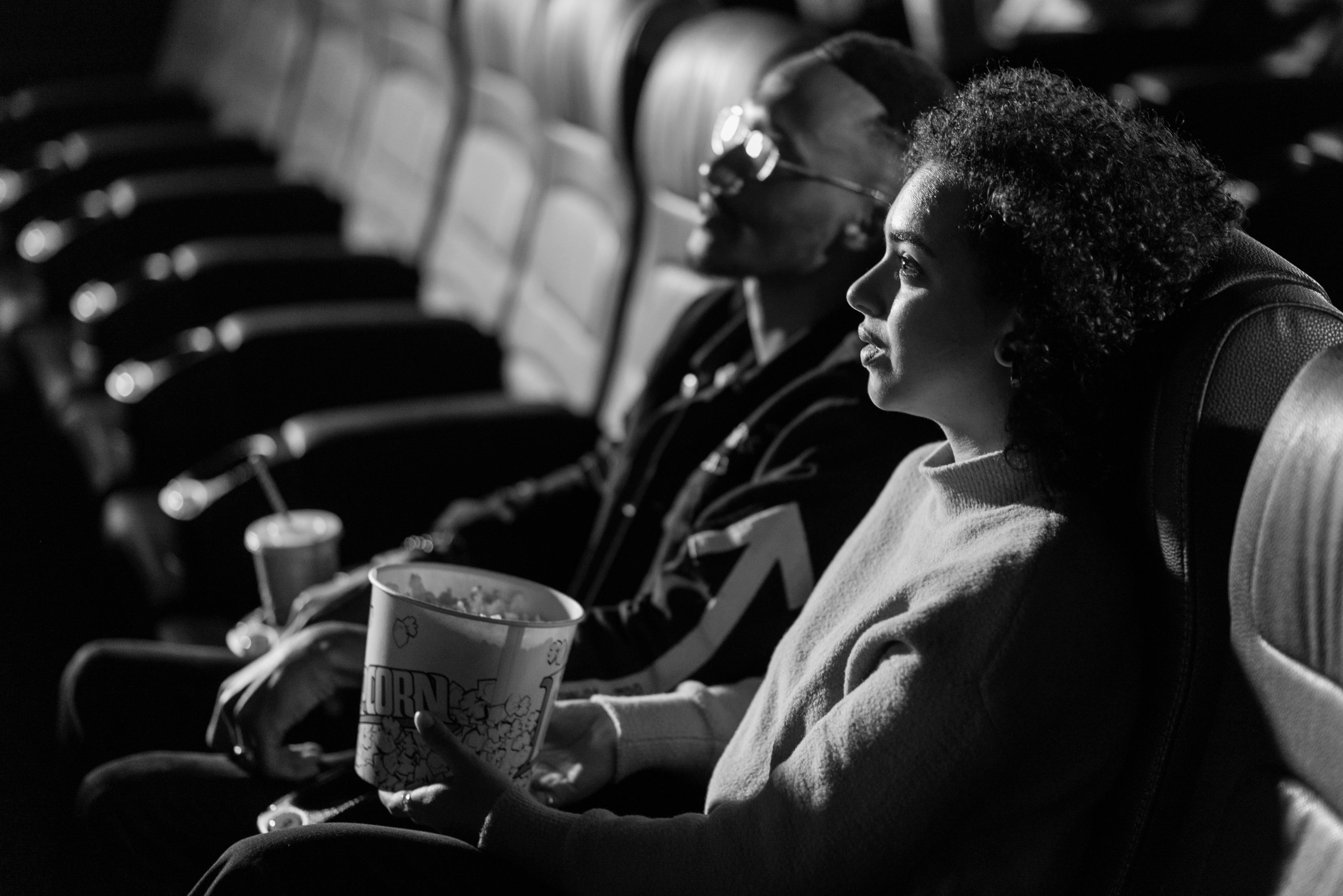 Grayscale Photo of a Man and a Woman Watching a Movie Together · Free Stock  Photo