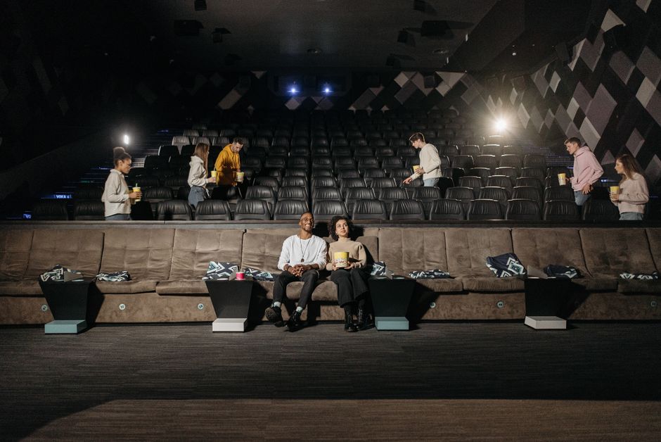 Residents enjoying a film in a luxury apartment theater - apartments with movie theater Residents enjoying a film in a luxury apartment theater - apartments with movie theater