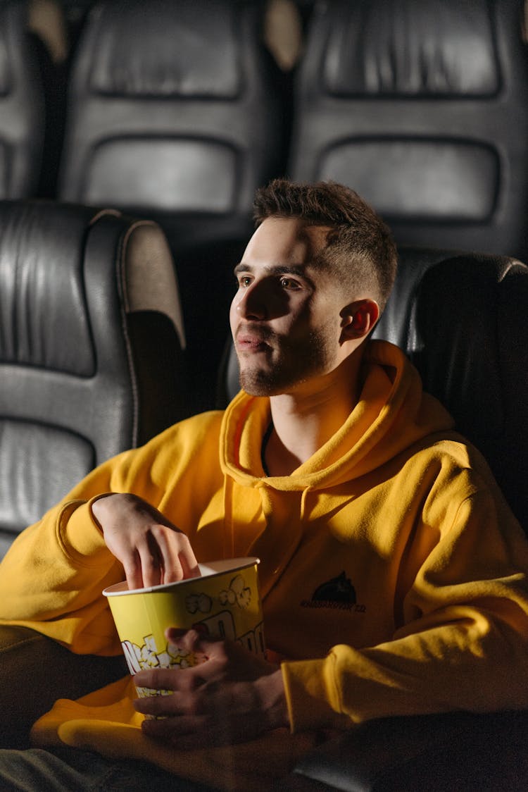 A Man In Yellow Hoodie Holding A Yellow Bucket