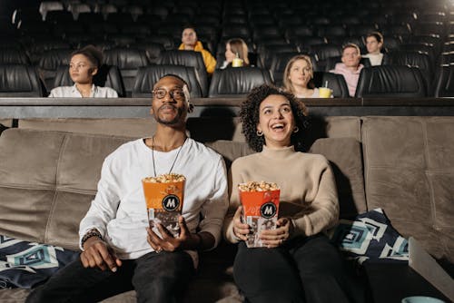 Couple Holding Popcorn Watching a Movie