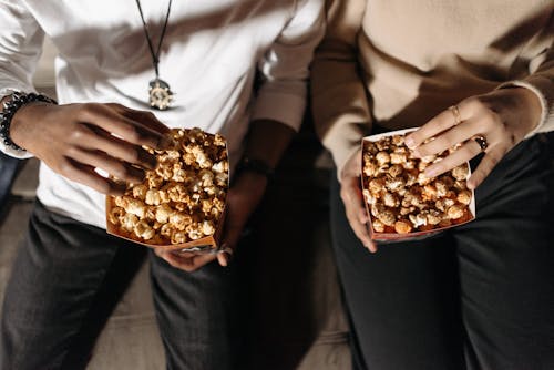 People Holding Bags of Popcorns