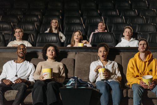 Free A diverse group of adults watching a movie in a theater, showcasing various expressions and emotions. Stock Photo