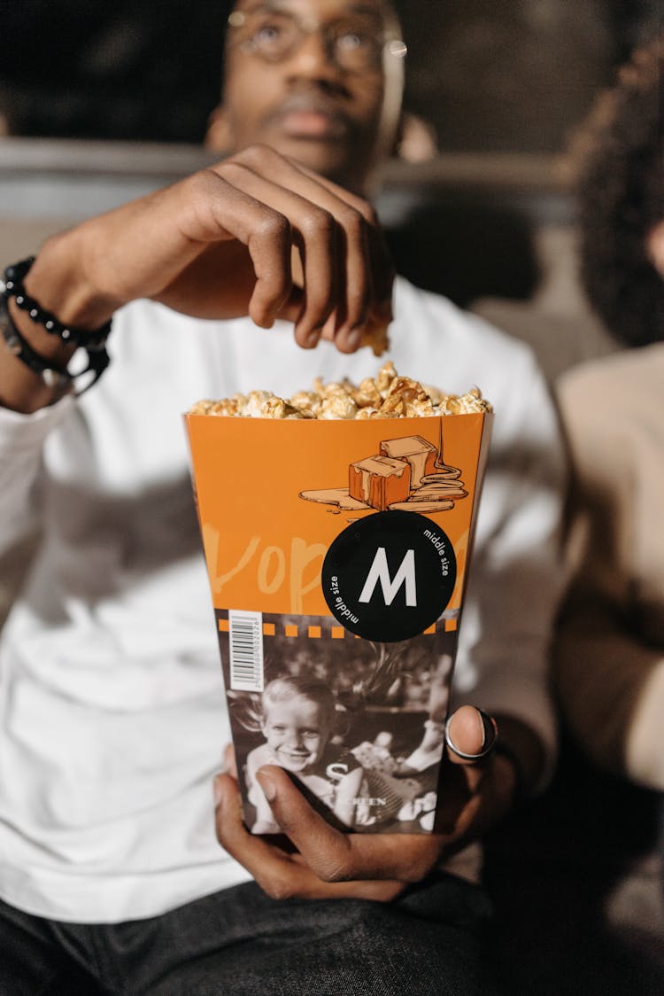 Photo Of A Man Holding A Bucket Of Caramel Popcorn