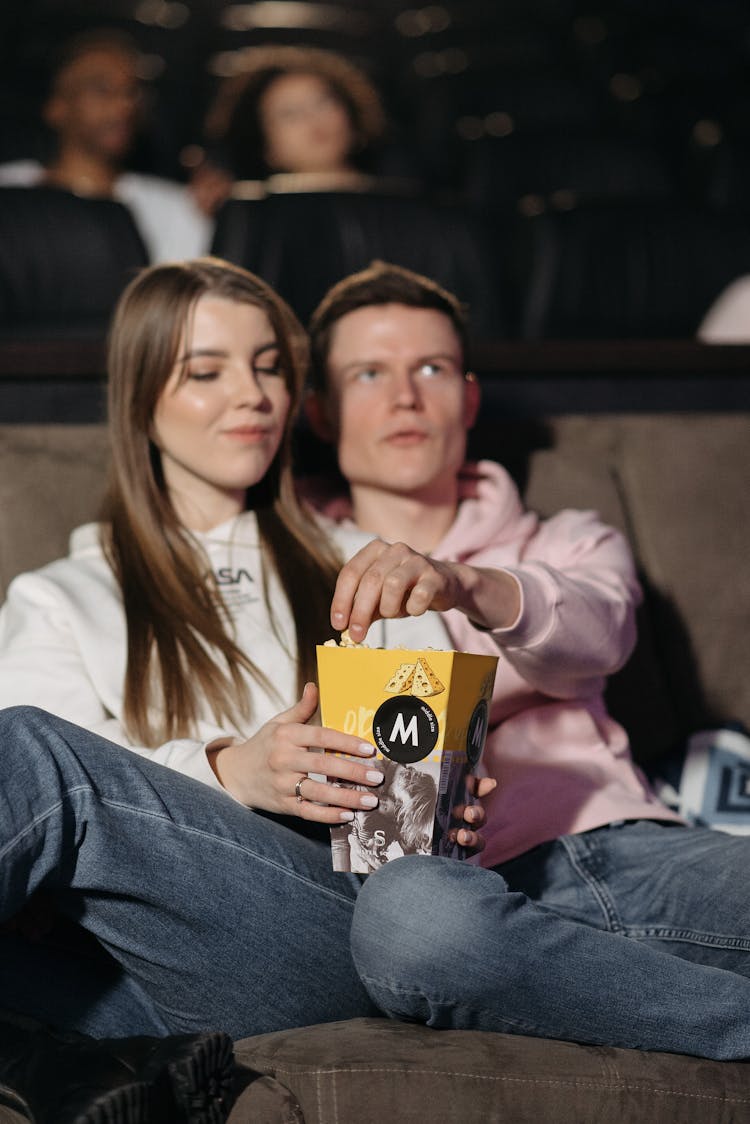 Couple Eating Popcorn In A Cinema