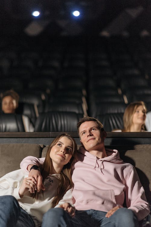 Man Embracing a Woman while Watching Movie in a  Theater 