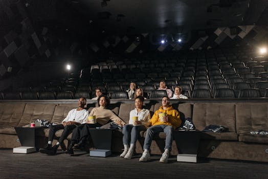 A diverse group of people enjoying a movie screening in an empty cinema with popcorn.