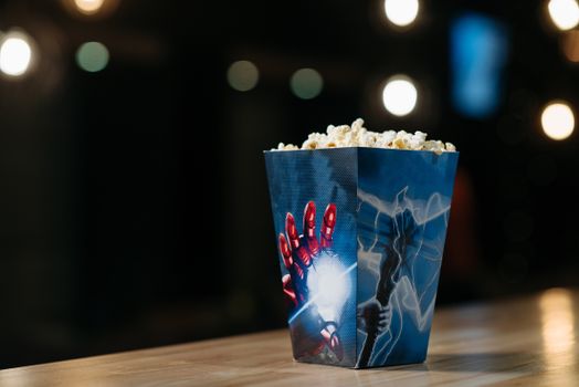 Close-up of popcorn in a themed box on a table, perfect for movie night promotions.