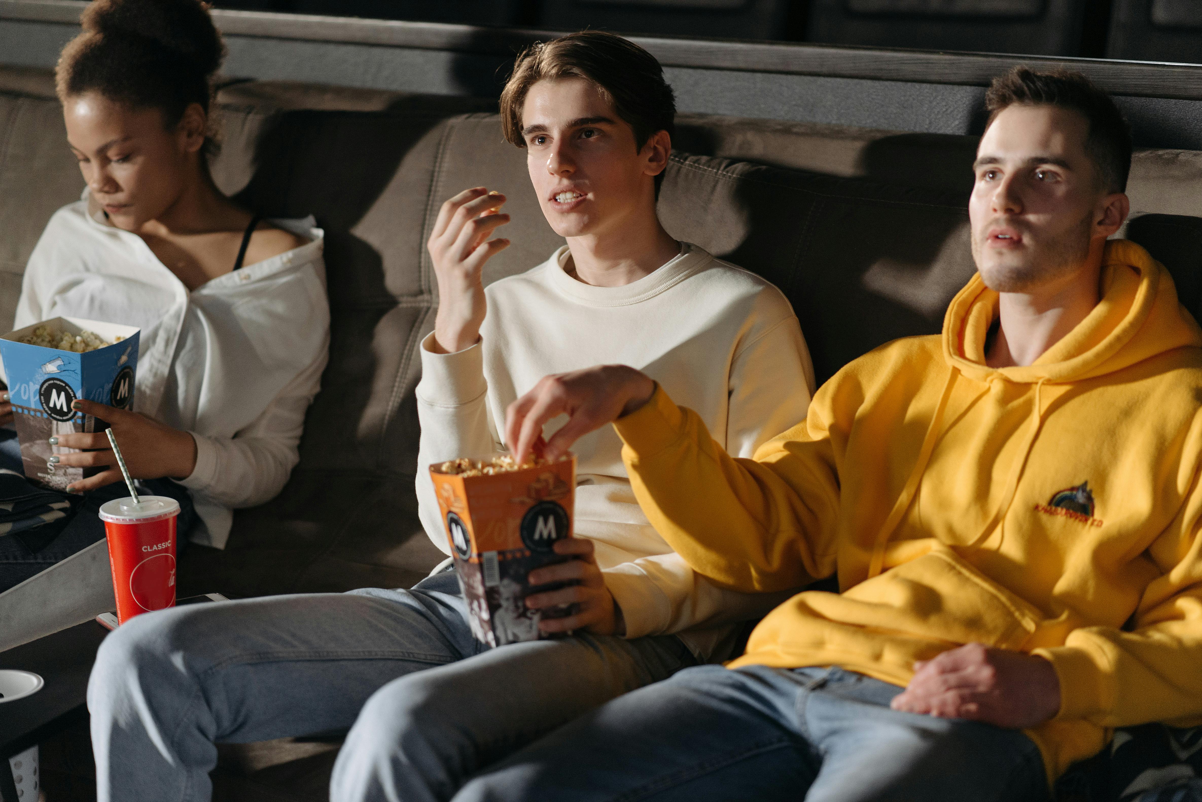 a people eating popcorn while watching a movie