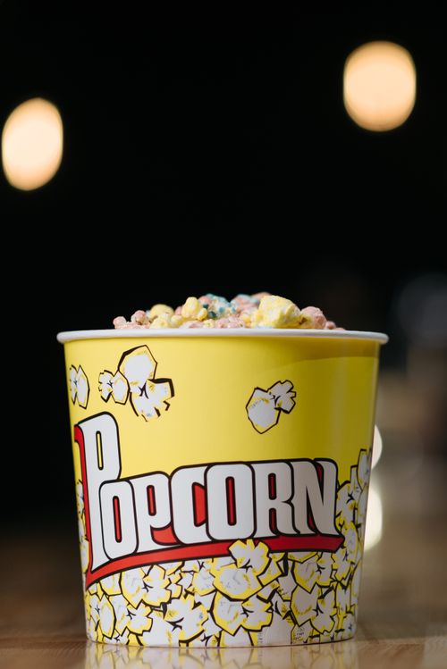 Free Close-up of colorful popcorn in a bright yellow bucket with a popcorn design. Stock Photo