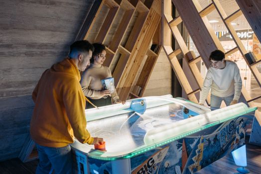 A fun indoor activity with friends playing air hockey in a modern recreation area.