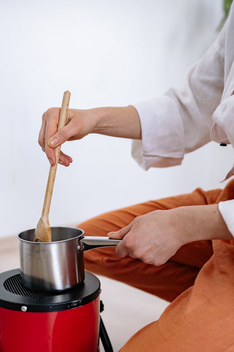 A Person Cooking With A Stainless Pot