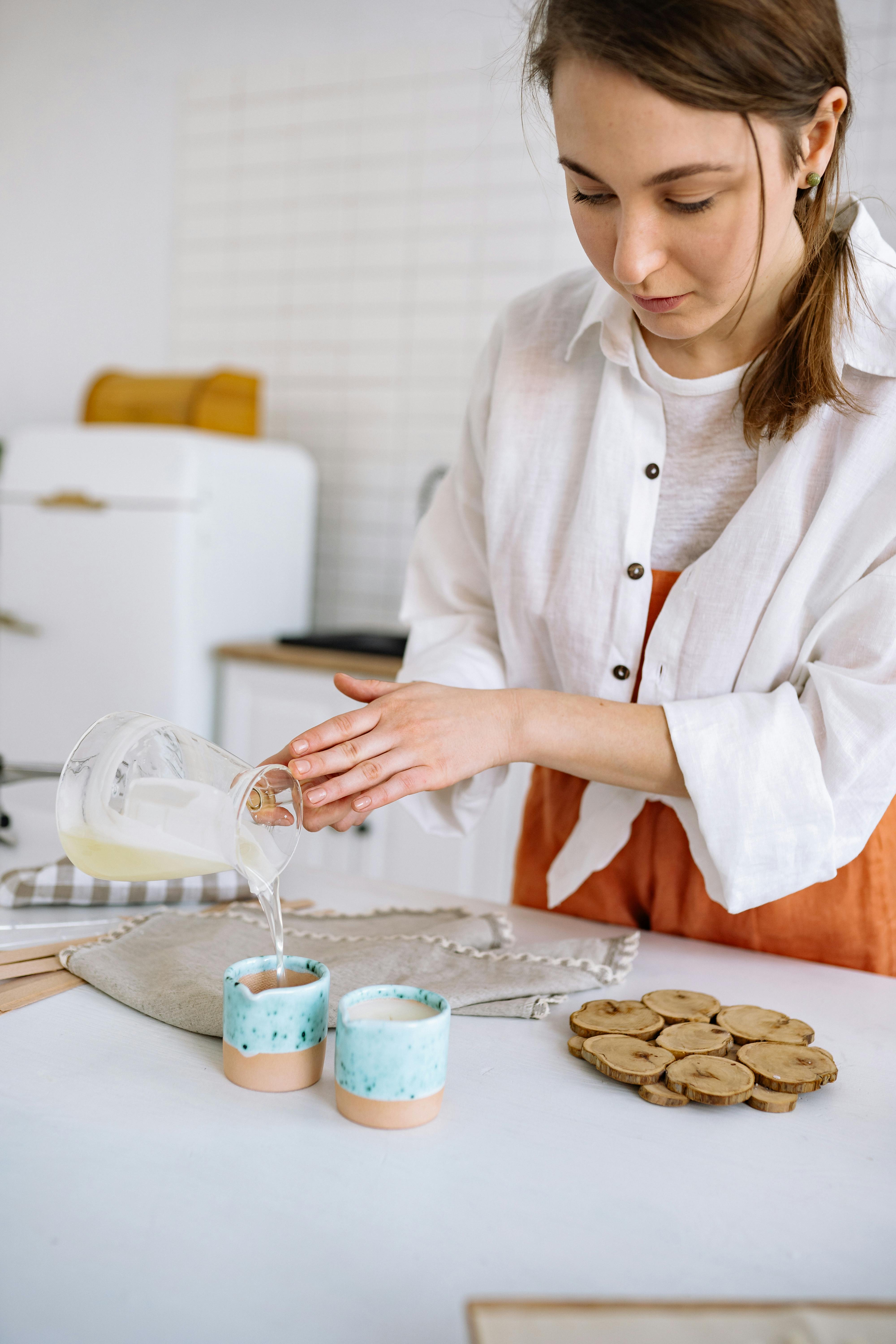 Woman Pouring Candle Wax on Cups · Free Stock Photo