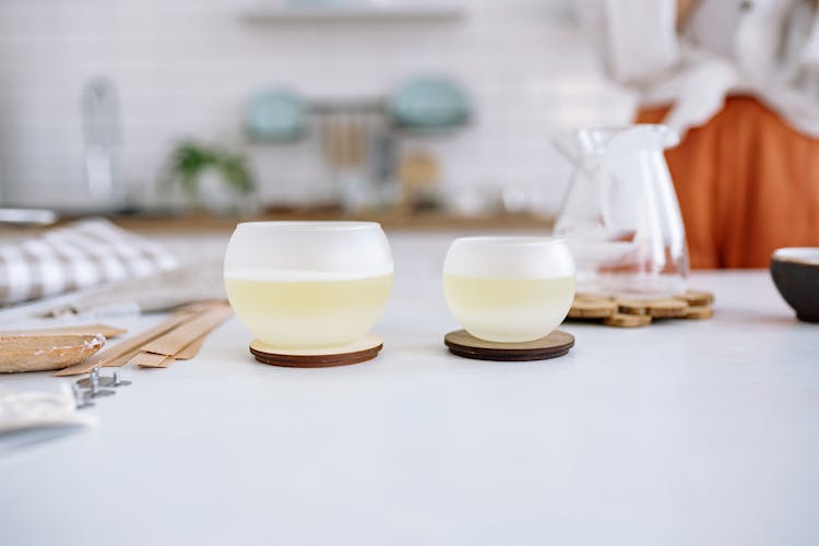 White  Round Containers On Brown Coasters