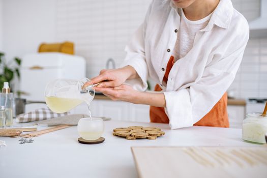 Woman Pouring Liquid Candle Wax in a Cup