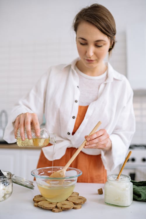 A Woman Pouring Liquid on Melted Wax