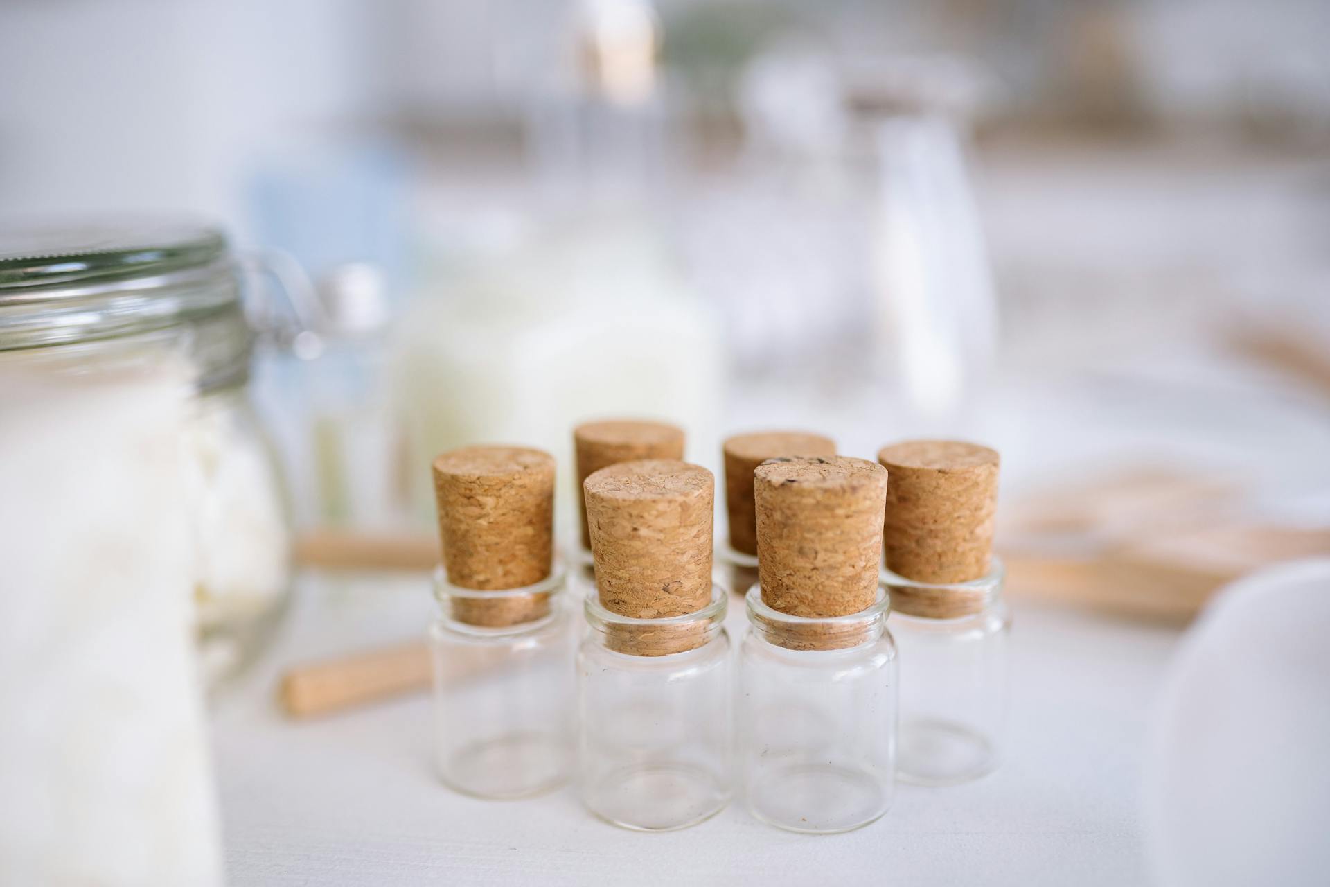 Minimalist image of small glass jars with cork lids on a blurred background. Ideal for storage concepts.