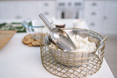 Free Close-up of a metal bowl with wax and a scoop, essential for candle making. Stock Photo