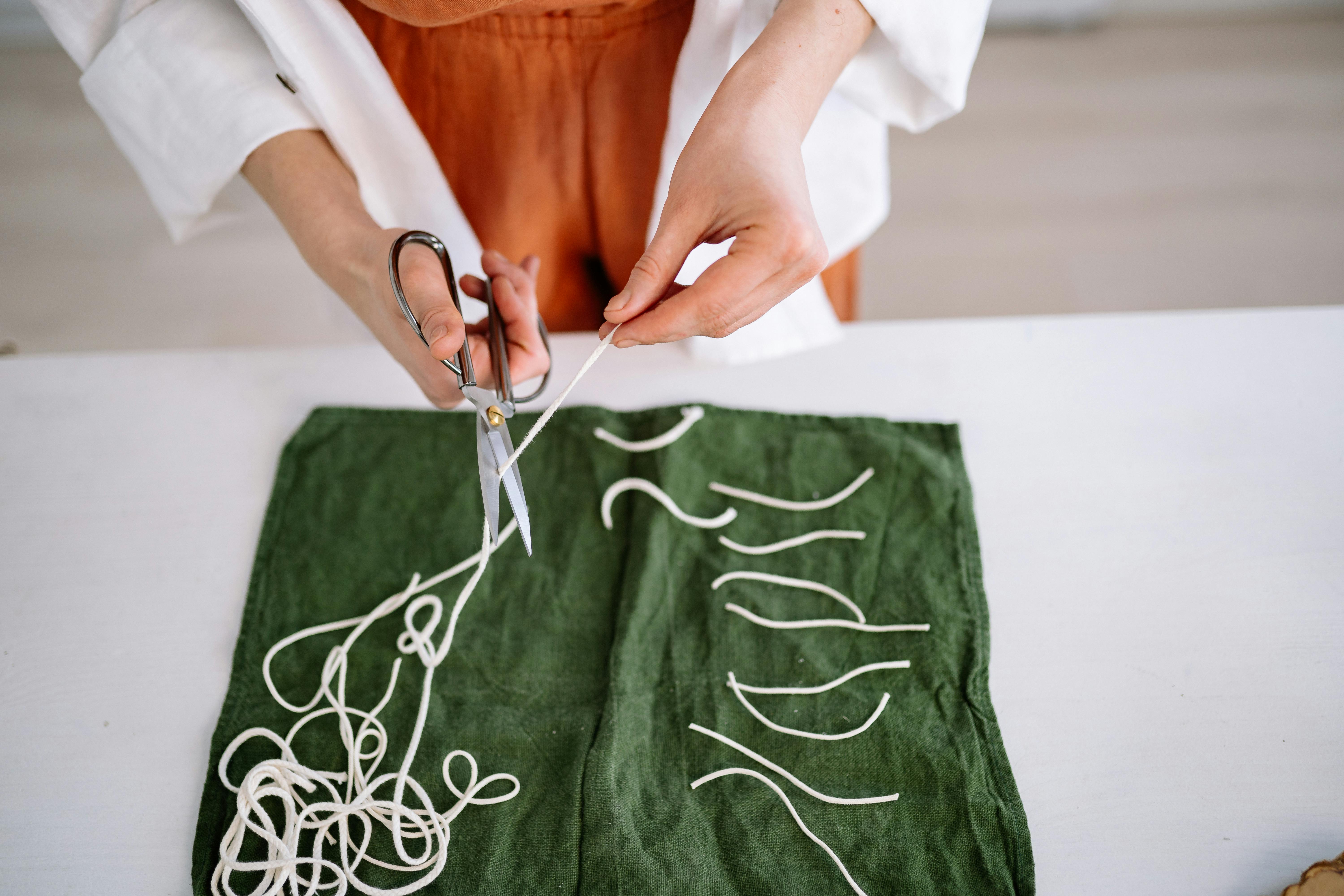 Person Cutting The Wicks As Preparation For Candle Making · Free Stock