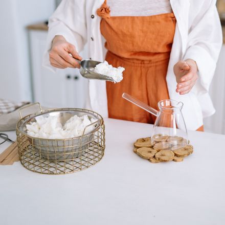 Maker scooping wax at a studio bench, photo by Yan Krukau on Pexels