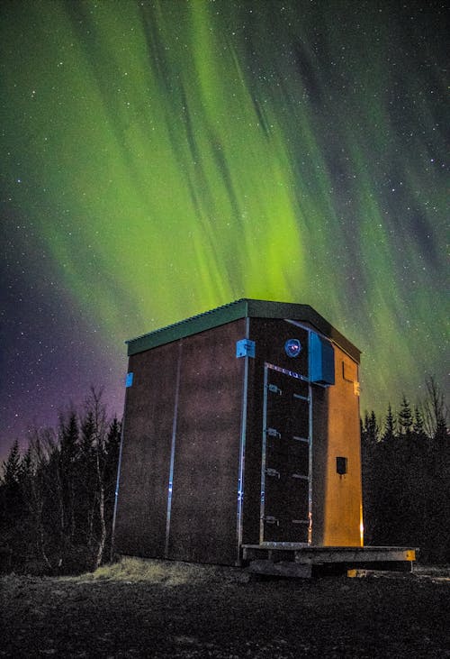 免费 木制棚屋在北极光下的照片 素材图片