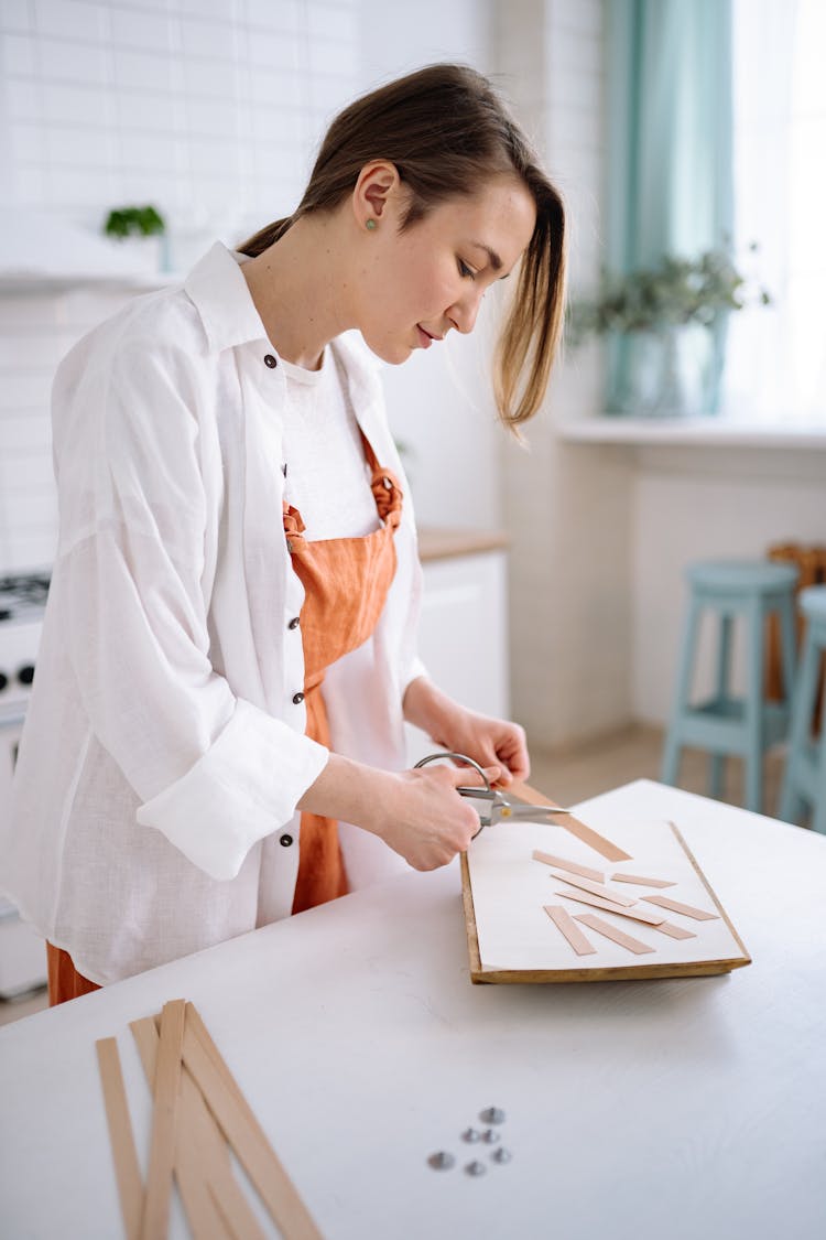 A Woman Cutting Wooden Strips
