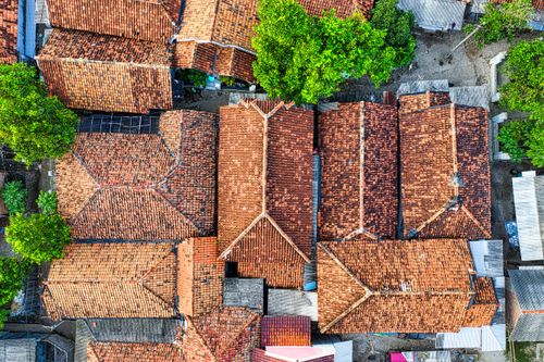 Free Aerial view of traditional brown tiled roofs surrounded by trees in Banten, Indonesia. Stock Photo