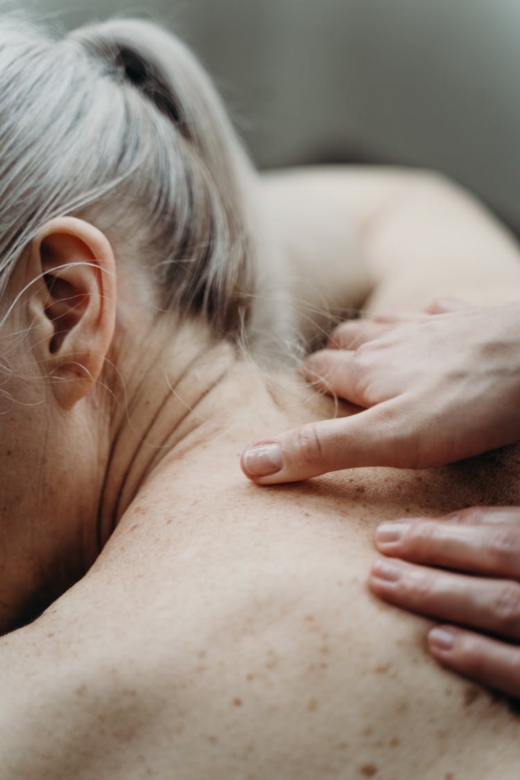 A Topless Woman Having A Shoulder Massage