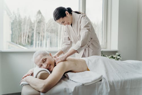 Photograph of an Elderly Woman Getting a Massage while Smiling