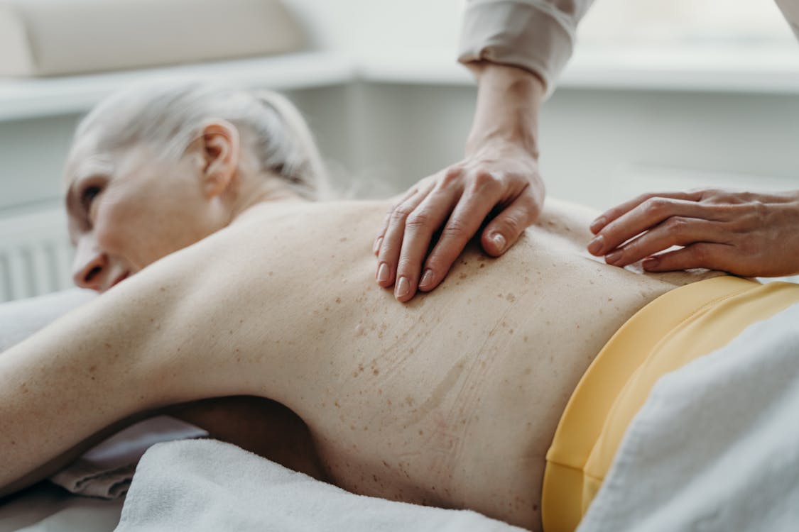 An elderly man getting a back massage, Stock image