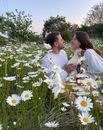 A Couple in the Flower Field Holding Geese