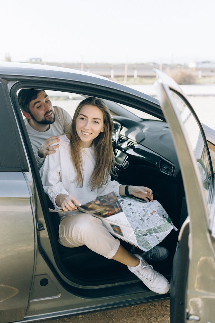 Photograph Of A Woman Holding A Map Getting Out Of A Car