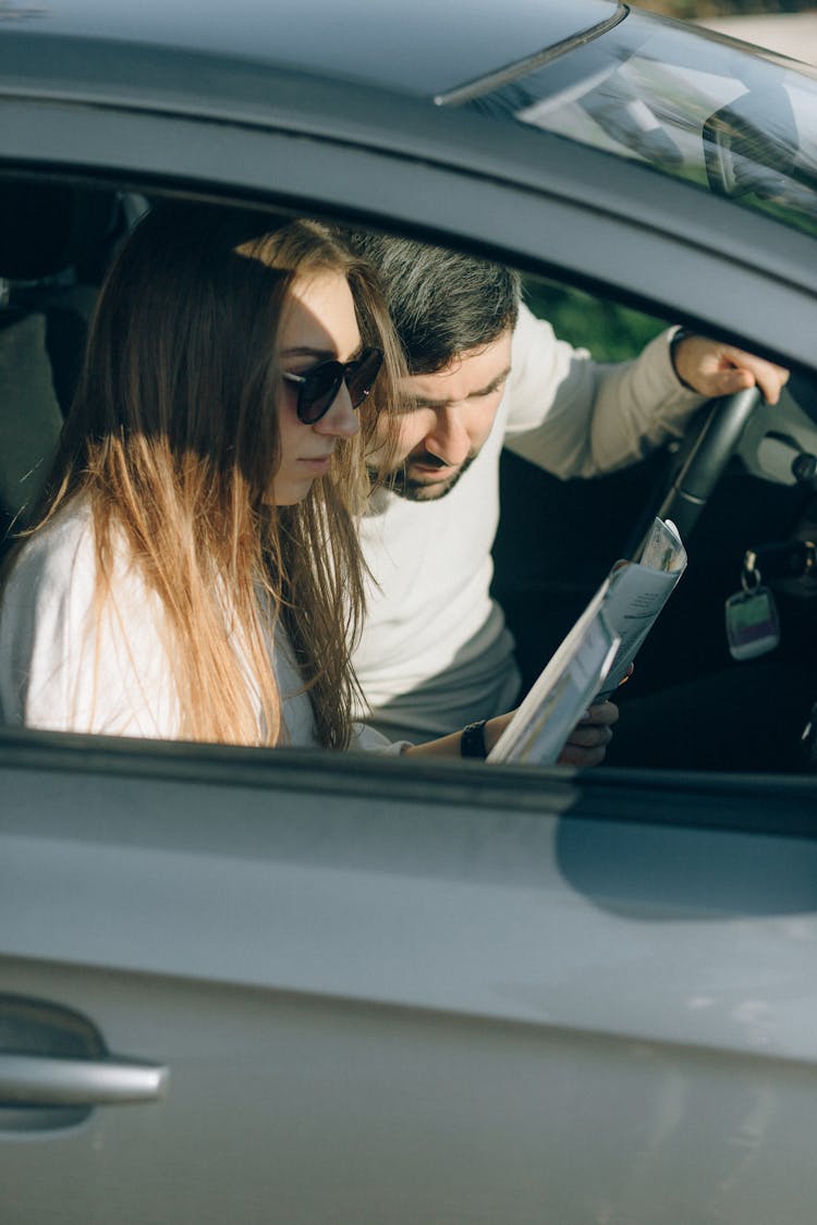 A Man And A Woman Looking At A Map