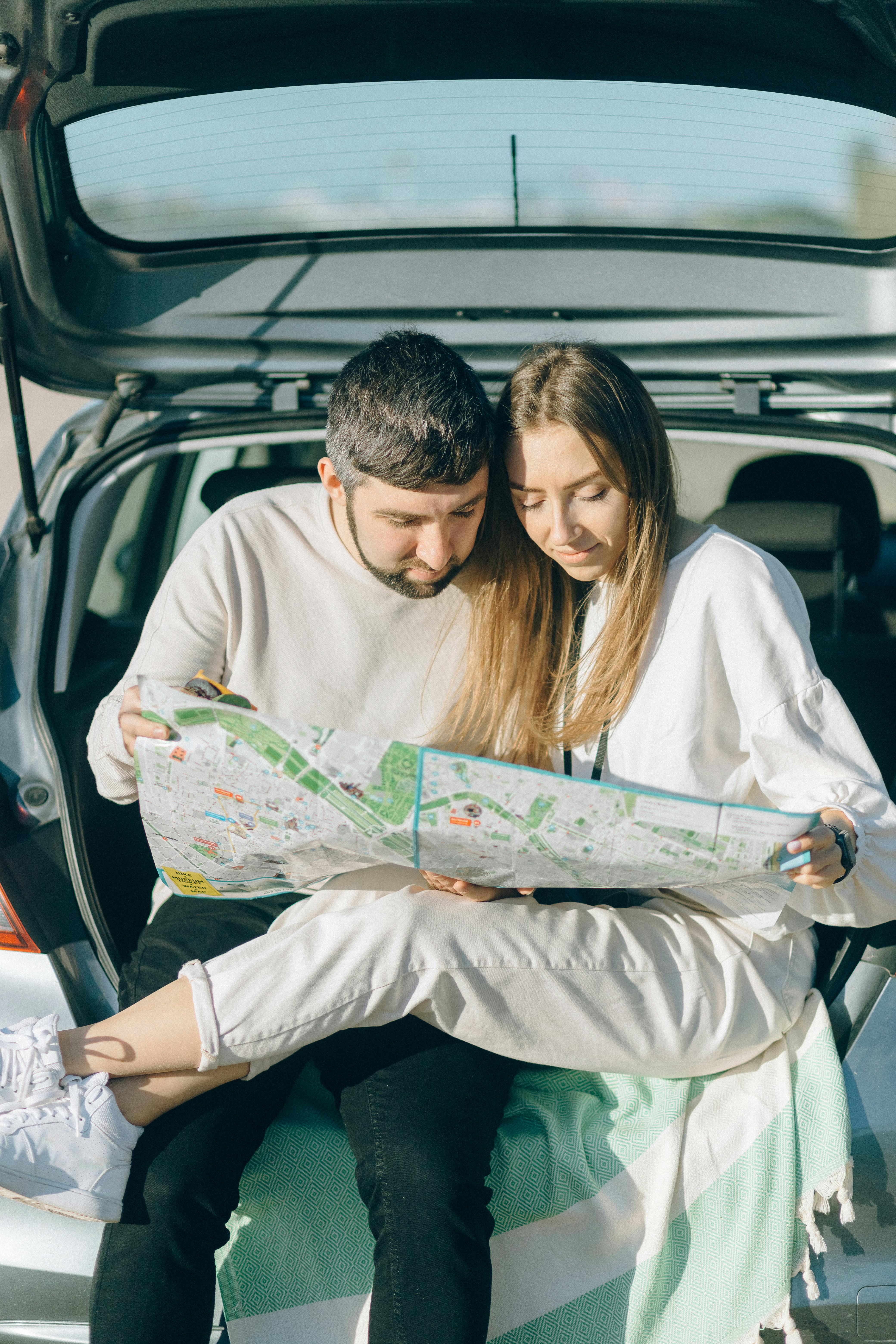 couple wearing white long sleeve shirts looking at a map