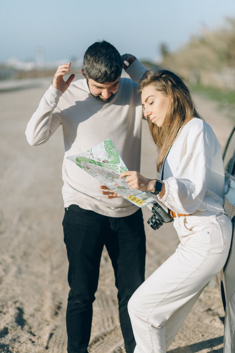 Couple Standing On Dirt Road Looking At A Map