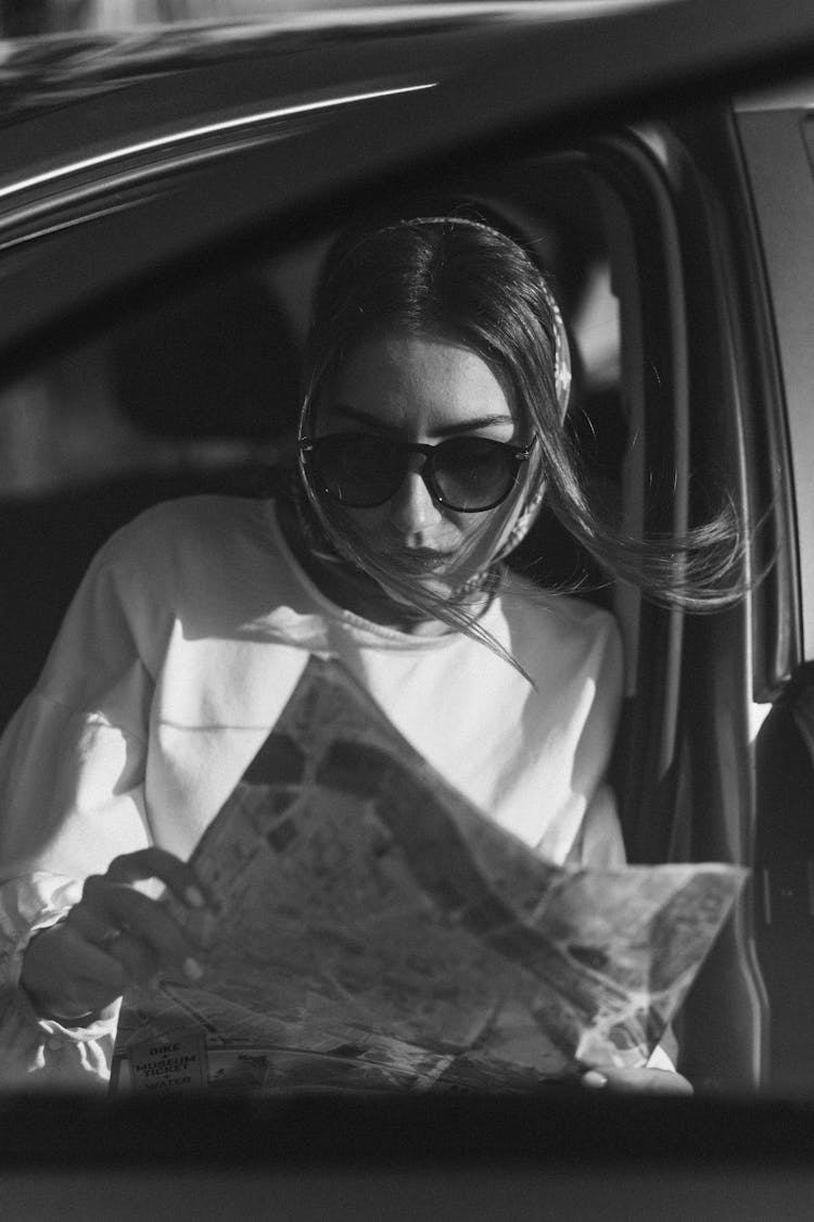 A Woman With Sunglasses Reading A Map