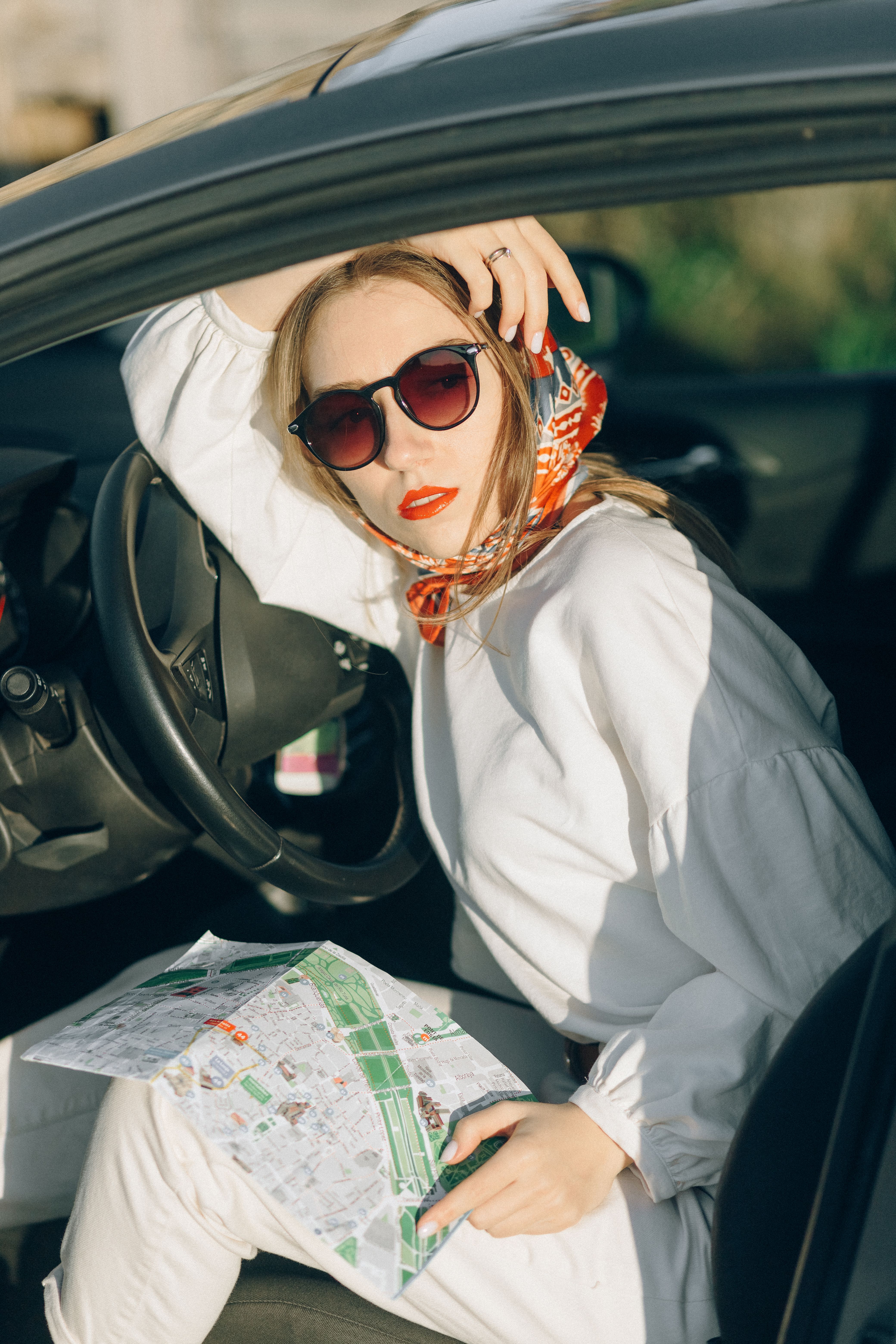 Woman in White Long Sleeve Shirt Sitting on a Car · Free Stock Photo