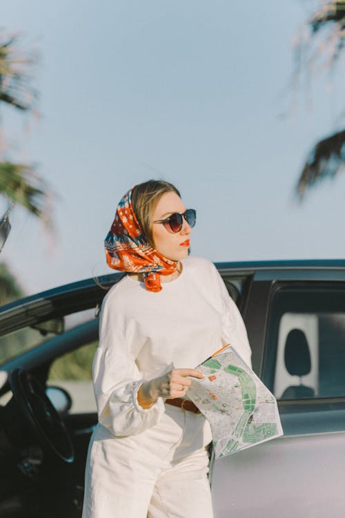 Free Photo of a Woman with a Headscarf Looking Away while Holding a Map Stock Photo