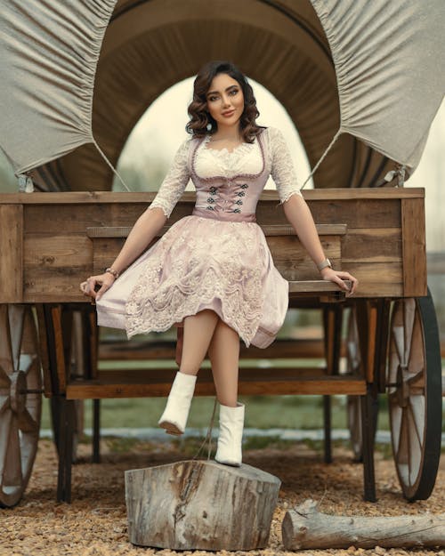 Free Woman in Pink Dress Sitting on a Wooden Carriage Stock Photo