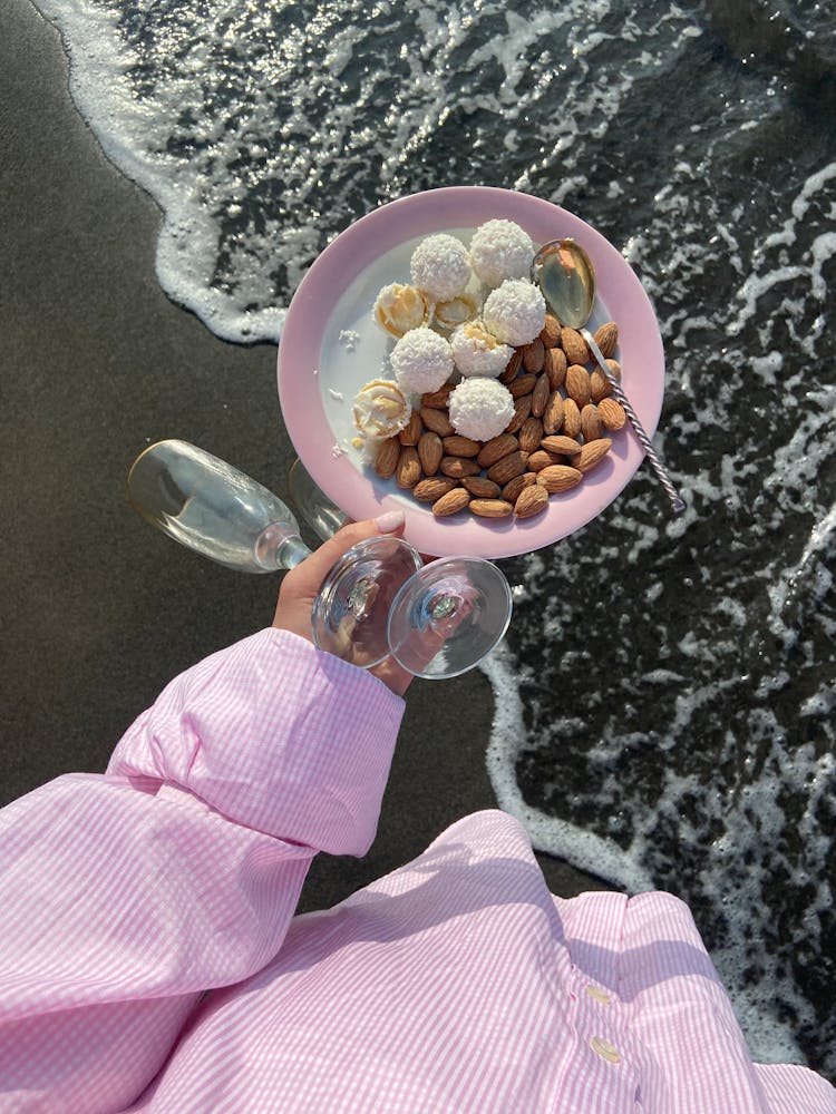 Crop Woman With Wineglasses And Food On Seashore