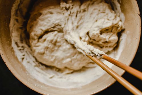 Free Close-up view of dough being mixed in a bowl using chopsticks, evoking a rustic kitchen feel. Stock Photo