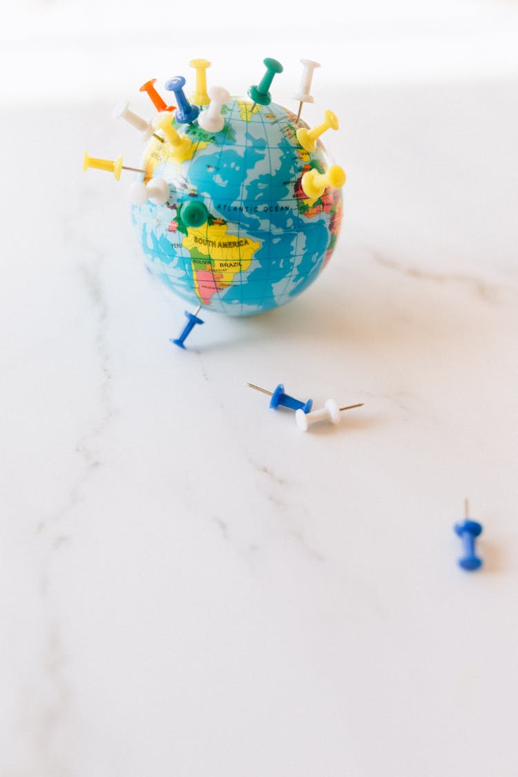 A Globe With Push Pins In Various Parts