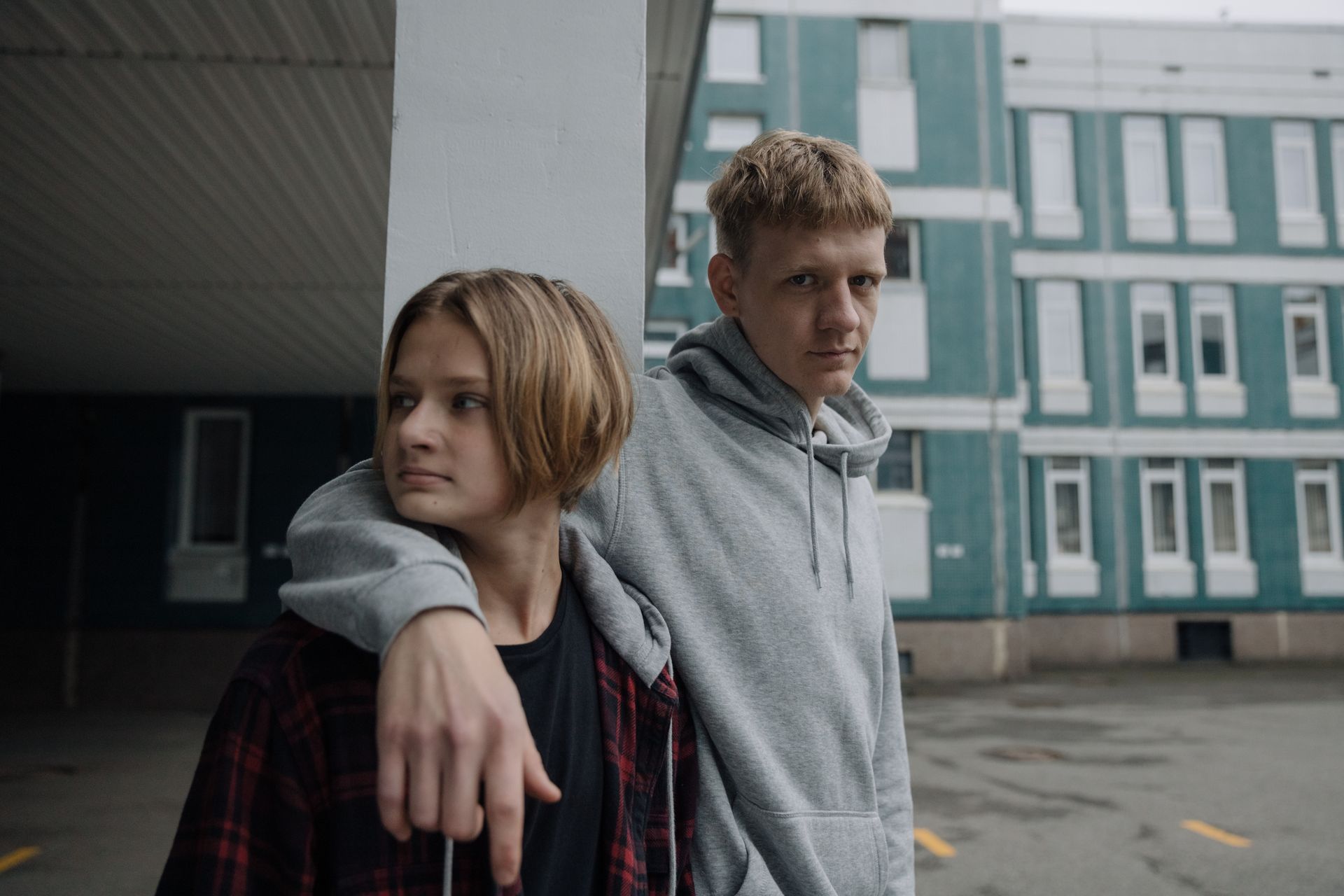 Two brothers standing outside a building in casual attire, expressing sibling bonding.