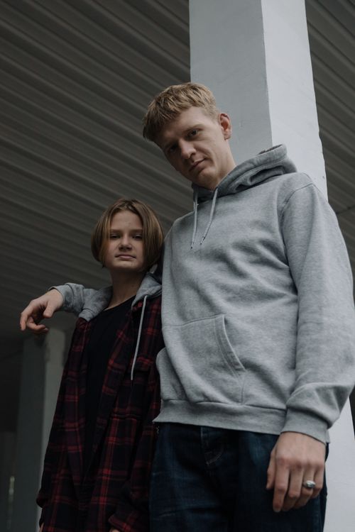 Free Two brothers in hoodies posing together with an urban backdrop, showcasing sibling camaraderie. Stock Photo
