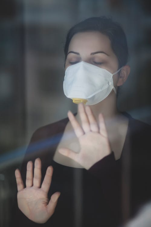 Woman in Black Long Sleeve Shirt Wearing White Face Mask