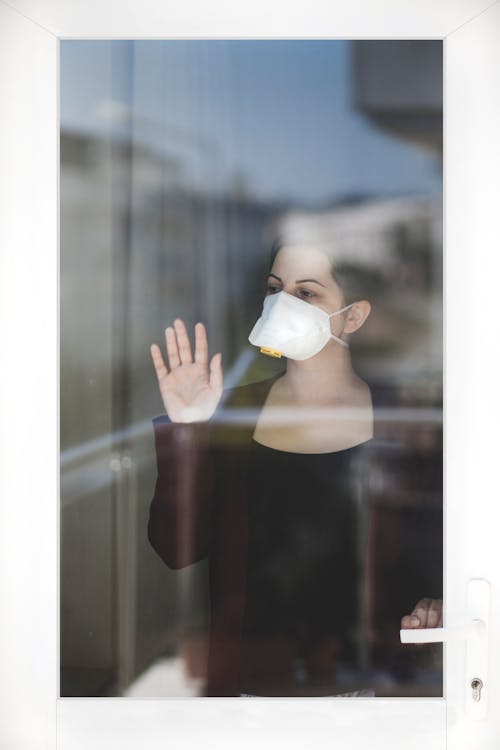 Free A Woman Wearing a Face Mask Looking Outside Stock Photo