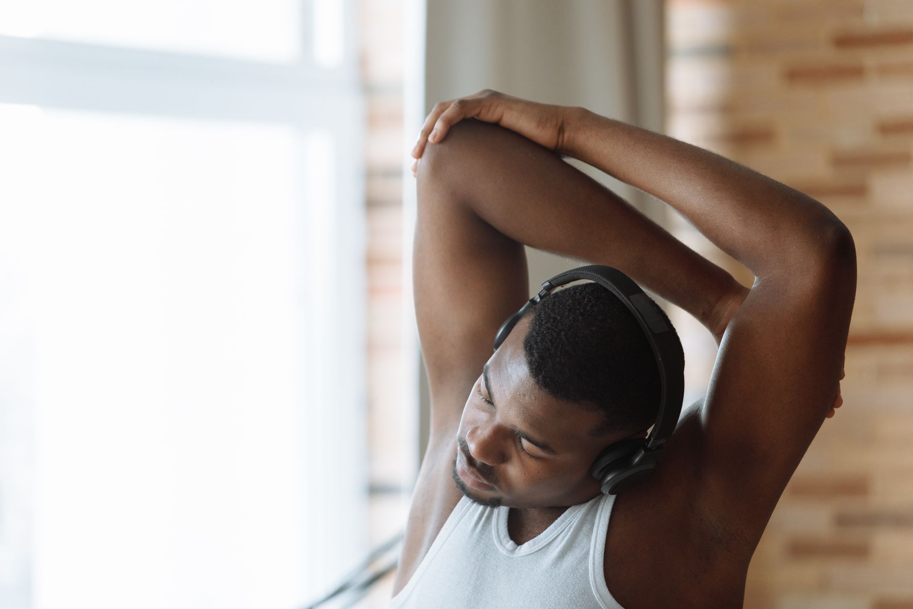 Indoor stretch with headphones at low volume during a calm morning