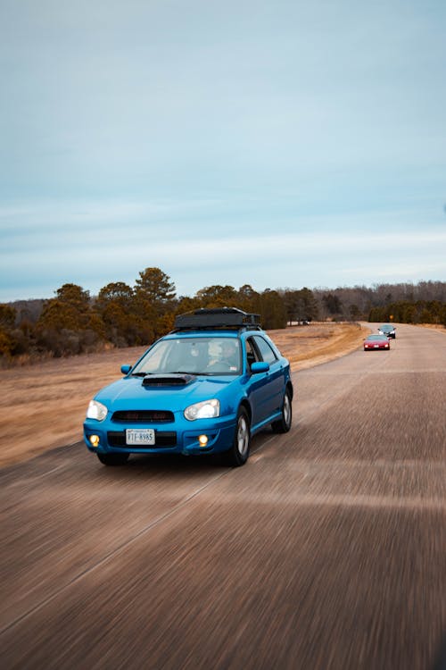 Photograph of a Blue Car on the Road