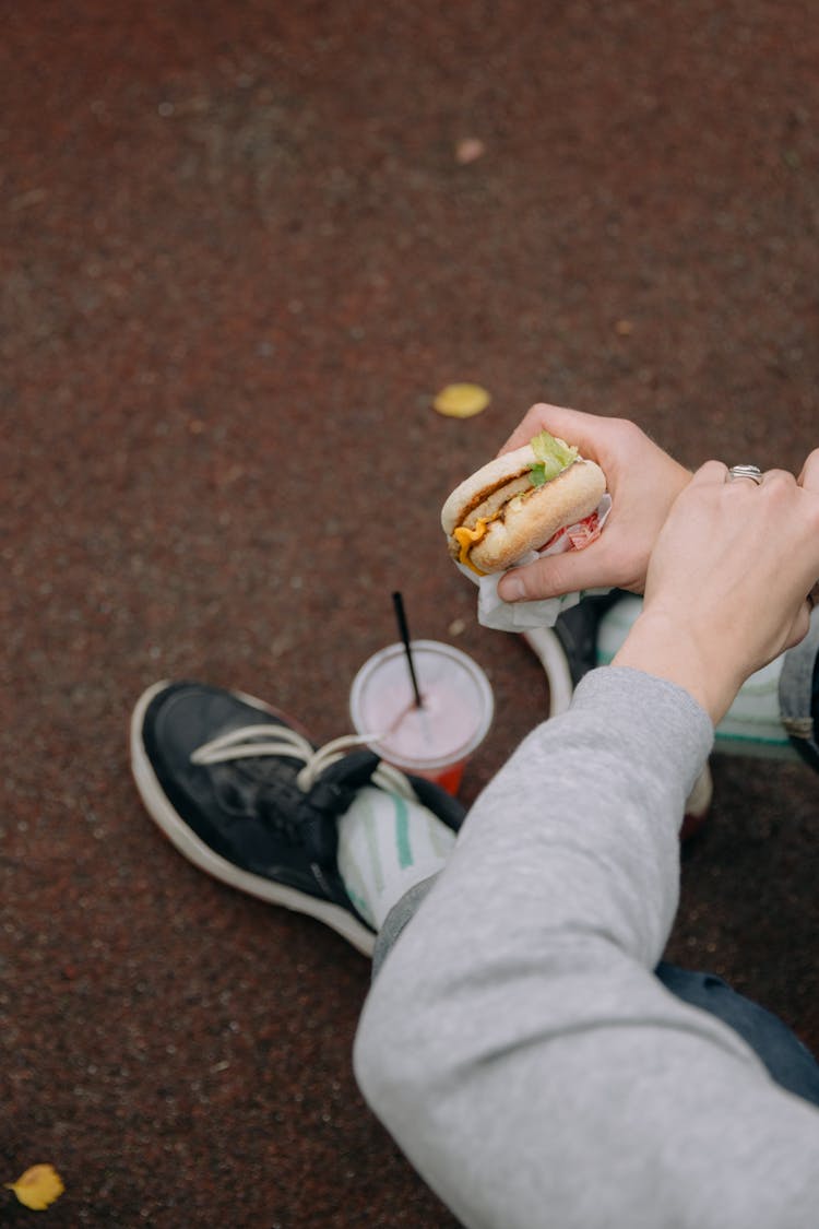 Person Holding A Burger 