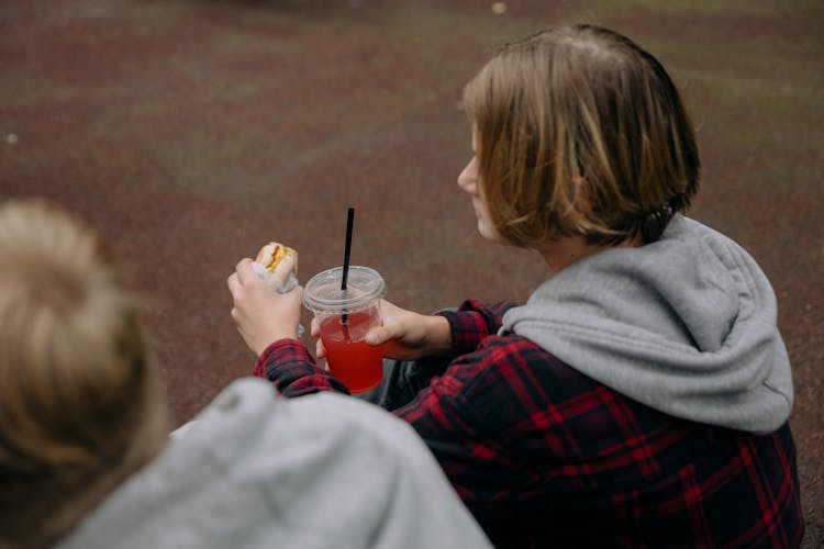 Person In Plaid Sweater Holding A Burger