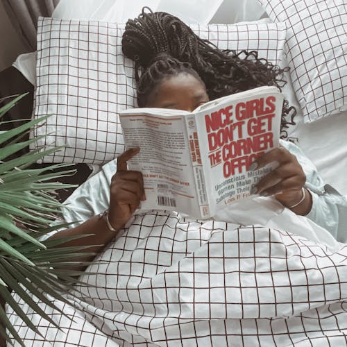 Woman Lying on Bed Reading a Book